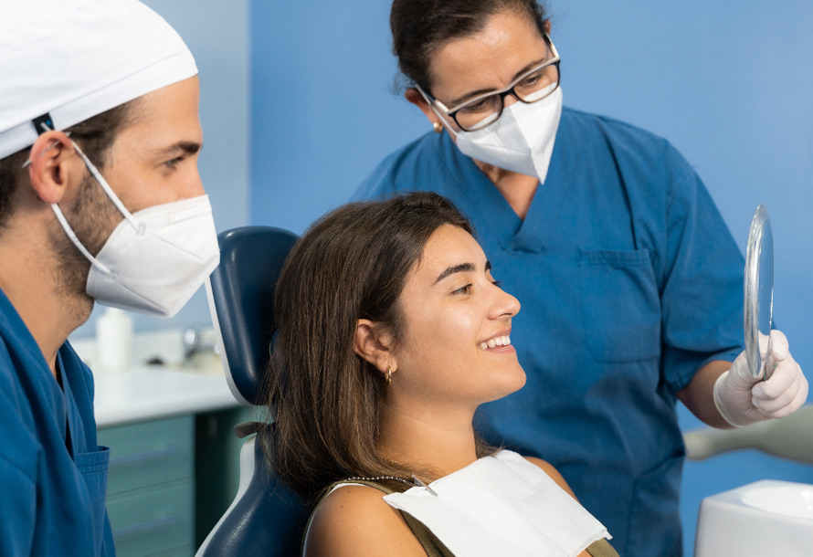 Chica viendose al espejo después de tratamiento dental